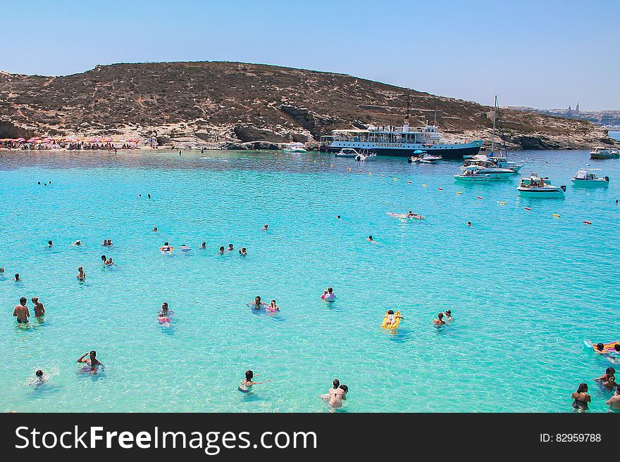 Swimmers In Blue Coastal Waters Of Malta