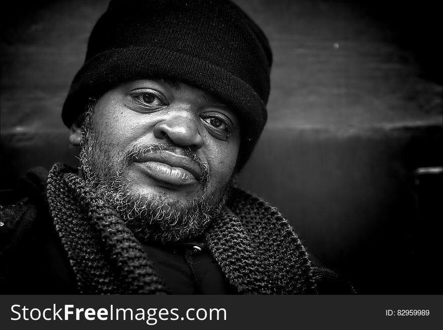 Portrait of man with beard wearing hat and scarf in black and white. Portrait of man with beard wearing hat and scarf in black and white.