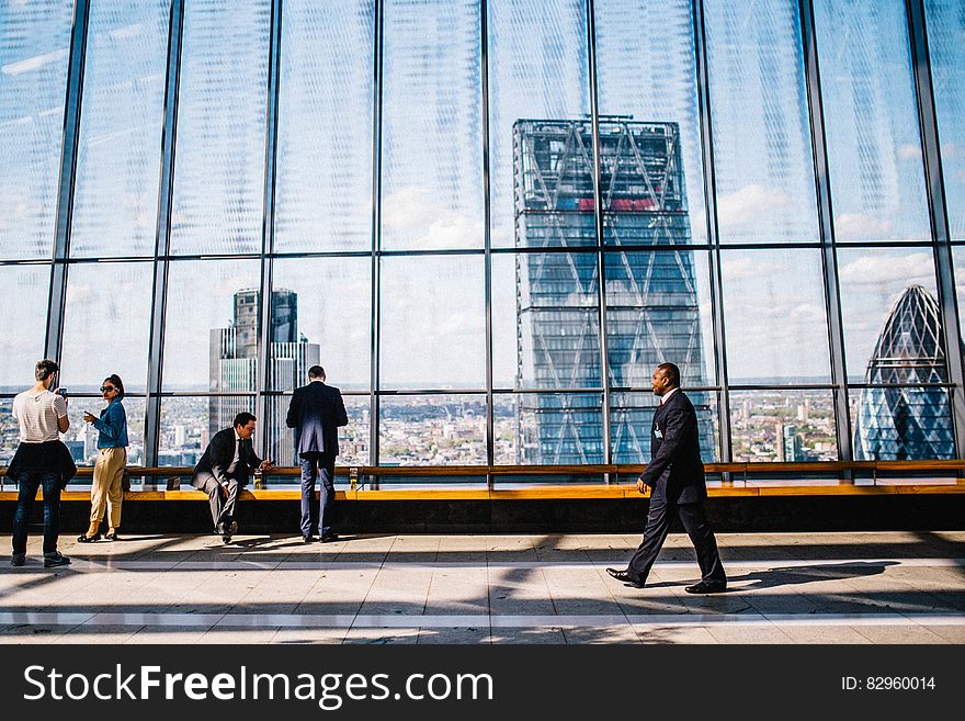 Visitors inside 20 Fenchurch in London, England with glass wall on sunny day. Visitors inside 20 Fenchurch in London, England with glass wall on sunny day.