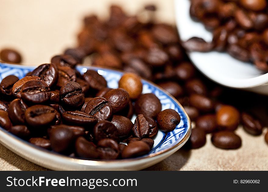 Close up of roasted Arabica coffee beans in blue china dish.