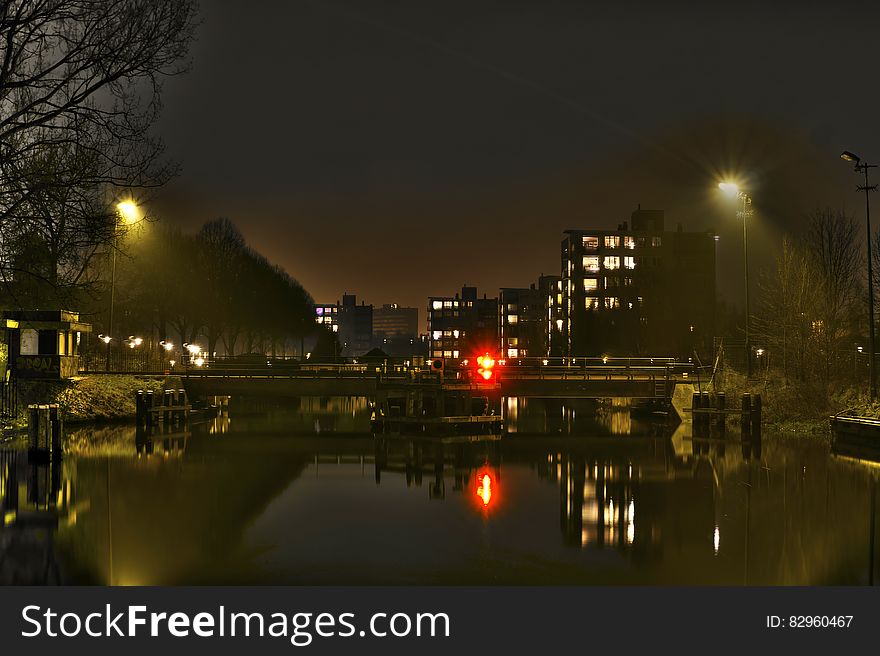 Urban lights reflecting in calm waters along waterfront. Urban lights reflecting in calm waters along waterfront.