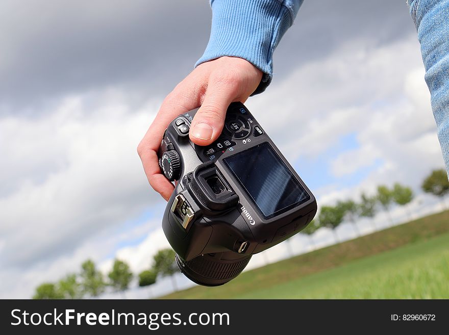 Person carrying digital camera outdoors