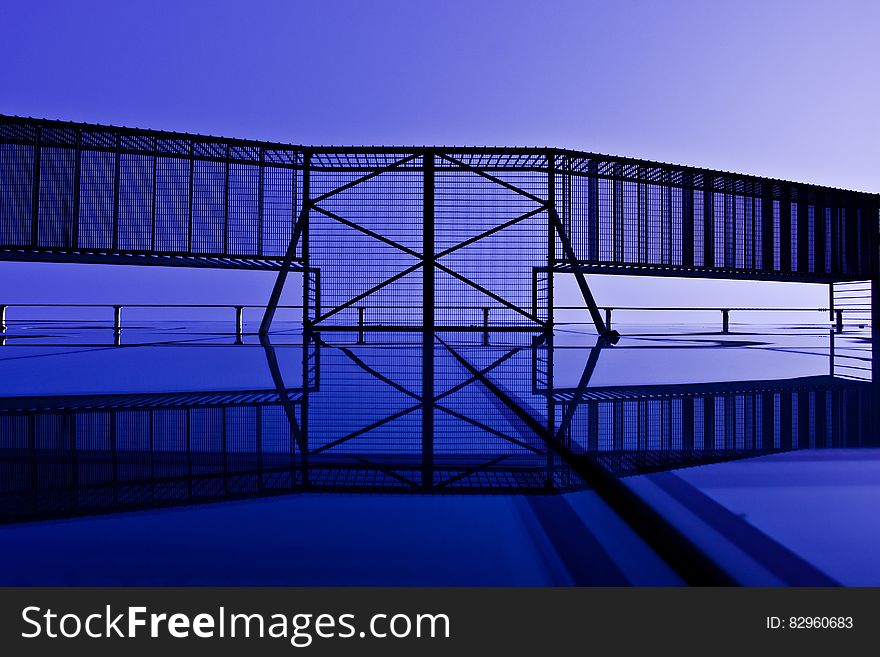 Abstract modern building facade showing underside of external staircase with blue tone.
