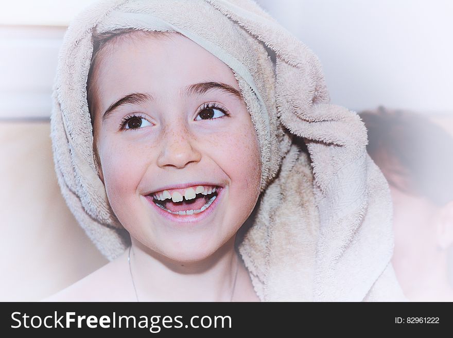 Portrait of young girl indoors smiling with terry cloth towel on head. Portrait of young girl indoors smiling with terry cloth towel on head.