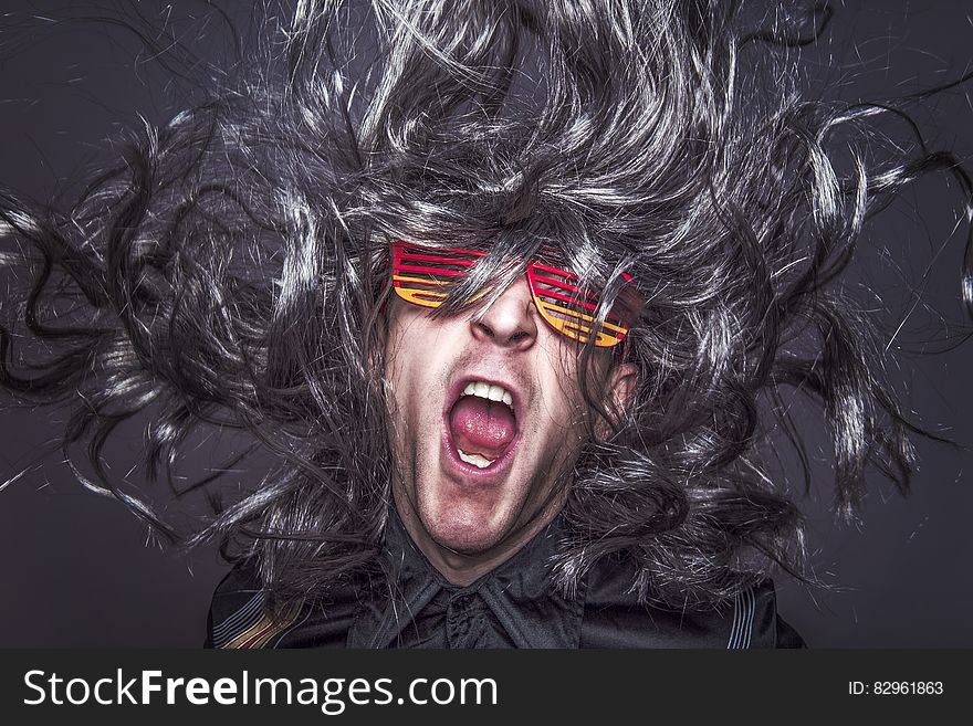 Man yelling with long grey hair wearing colorful sunglasses yelling with mouth open. Man yelling with long grey hair wearing colorful sunglasses yelling with mouth open.