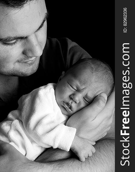 Grayscale Photo of Man Holding Baby