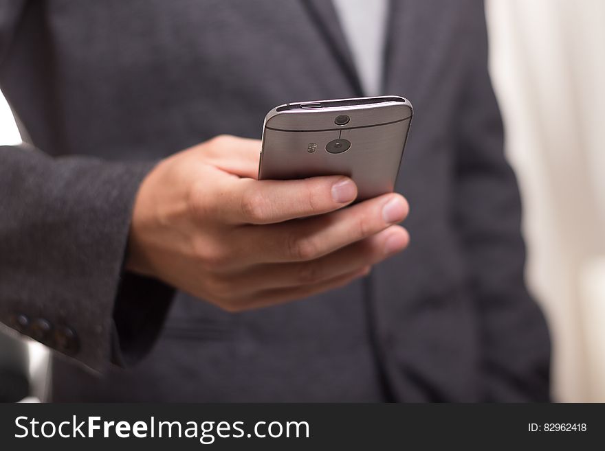 Man Wearing Black Suit Jacket Holding Gray Htc Android Smartphone