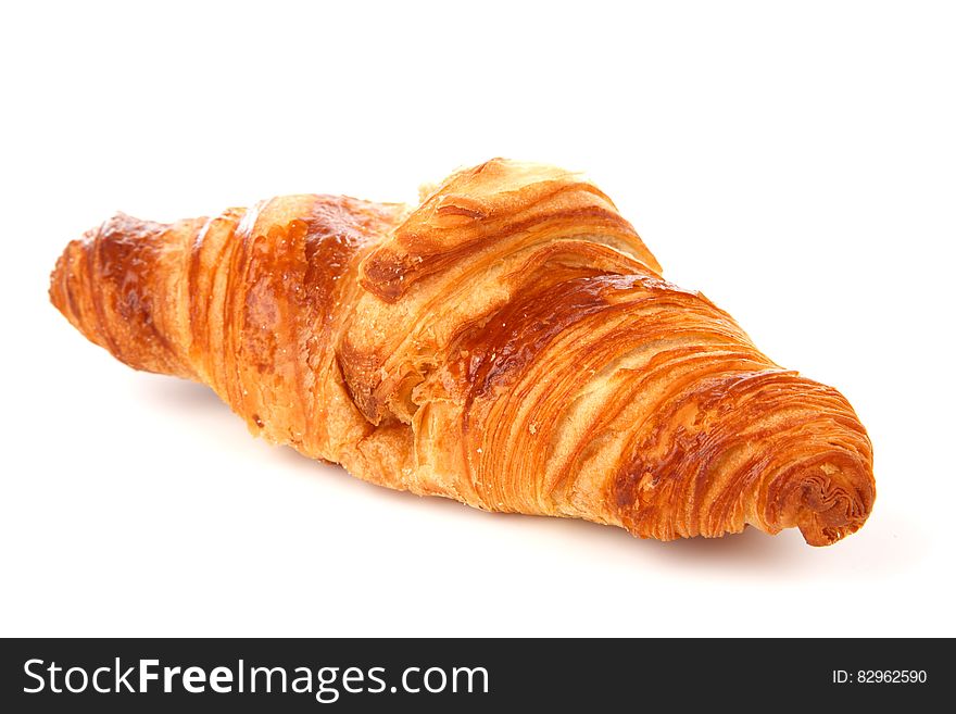 French croissant, a breakfast pastry, eaten with coffee, perfectly baked, white background.