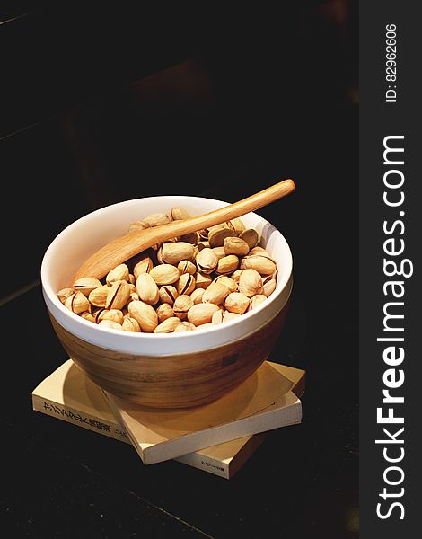 Pistachio Nuts in White and Brown Ceramic Bowl With Brown Wooden Spoon