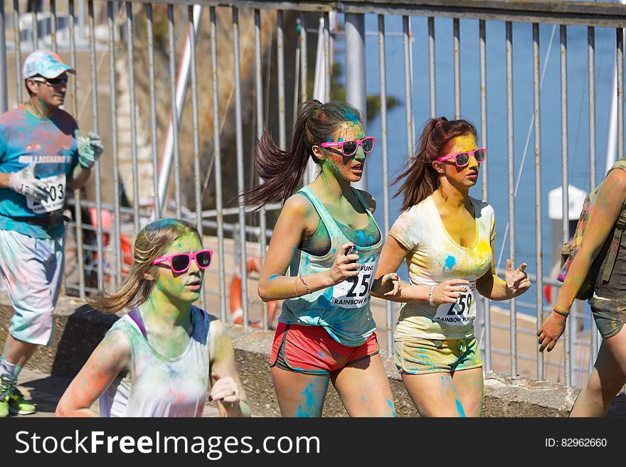Group of young female joggers with painted faces taking park in marathon. Group of young female joggers with painted faces taking park in marathon.