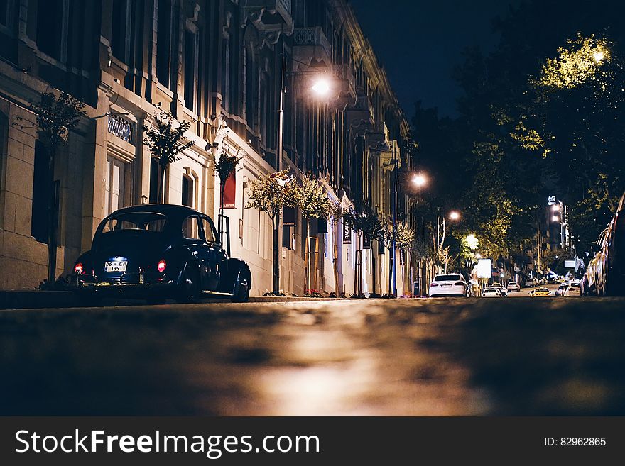 Black car parked in street in Istanbul, Turkey, with illuminated historic buildings at night, black sky background. Black car parked in street in Istanbul, Turkey, with illuminated historic buildings at night, black sky background.