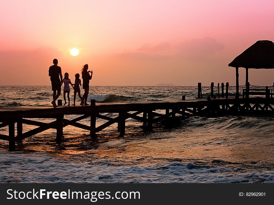 People Standing on Dock during Sunrise