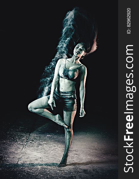 Retro impression of ballet dancer under the spot light with minimal costume and unusually without shoes. Suggestion of rising smoke to create atmosphere, dark background. Retro impression of ballet dancer under the spot light with minimal costume and unusually without shoes. Suggestion of rising smoke to create atmosphere, dark background.