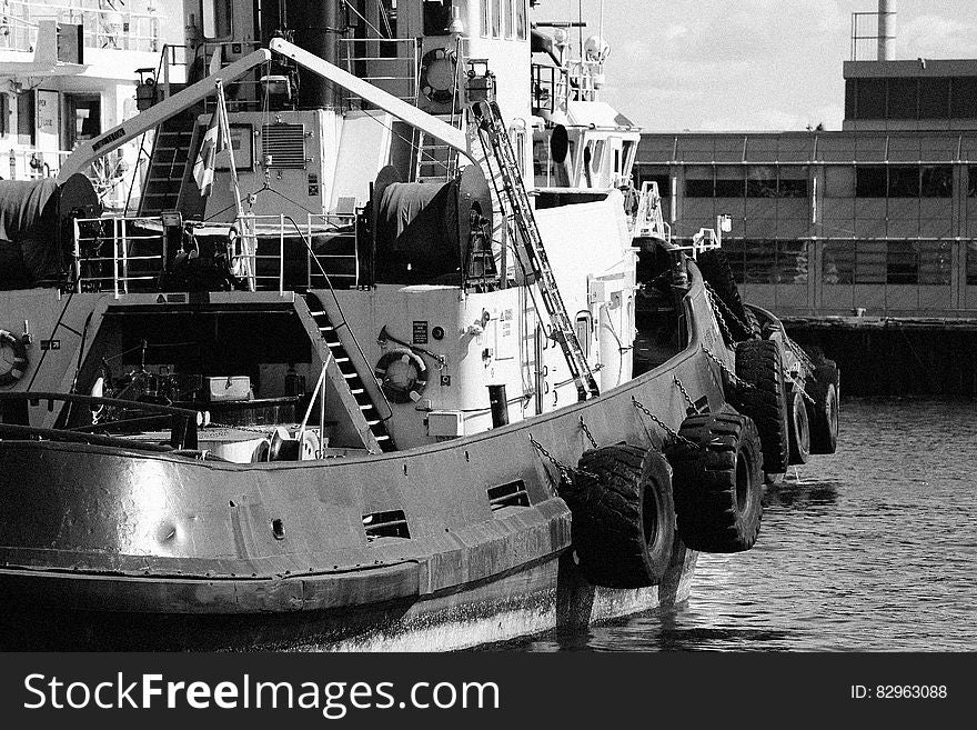 A black and white photo of a fishing boat in a harbor.