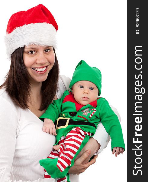 Smiling Woman Wearing Santa Hat Carring Baby Wearing Elf Costume