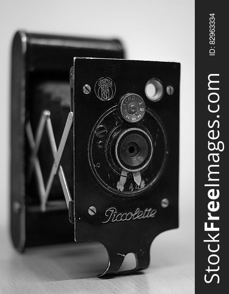 Vintage Piccolette camera lens in black and white.