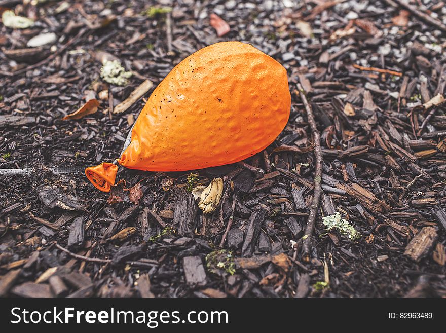 A deflated orange balloon lying on ground. A deflated orange balloon lying on ground.