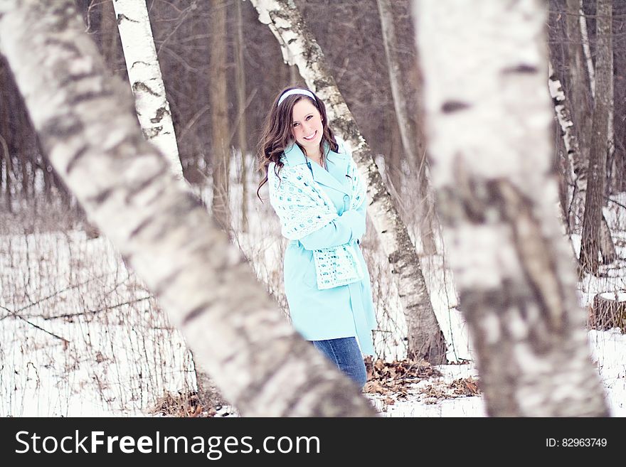 Smiling young girl walking though snow covered wintry forest. Smiling young girl walking though snow covered wintry forest.