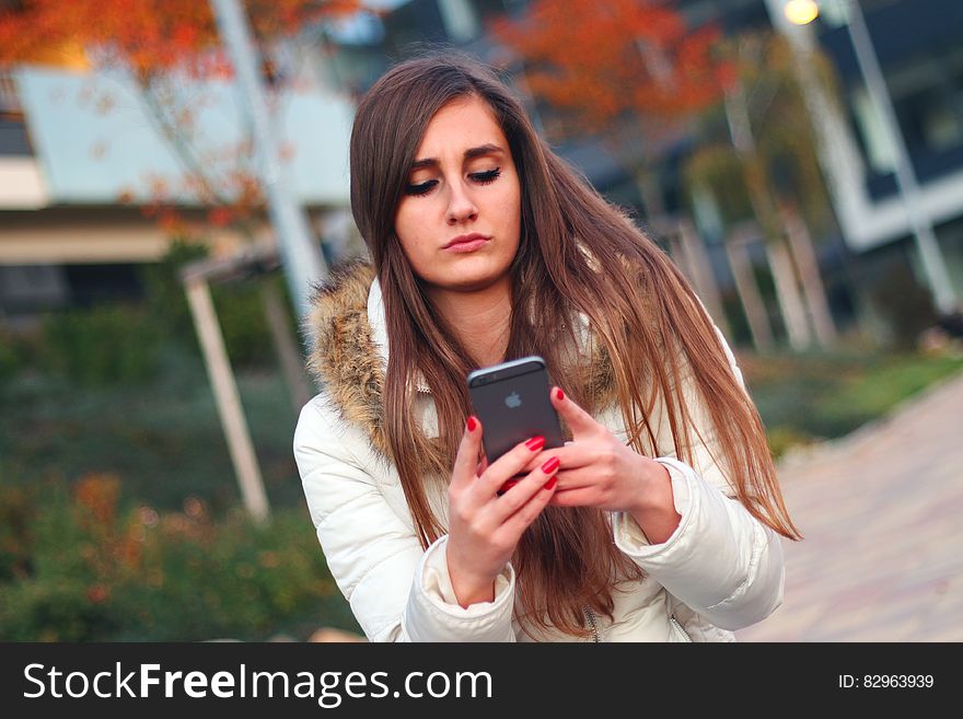 A woman using her smartphone outdoors. A woman using her smartphone outdoors.