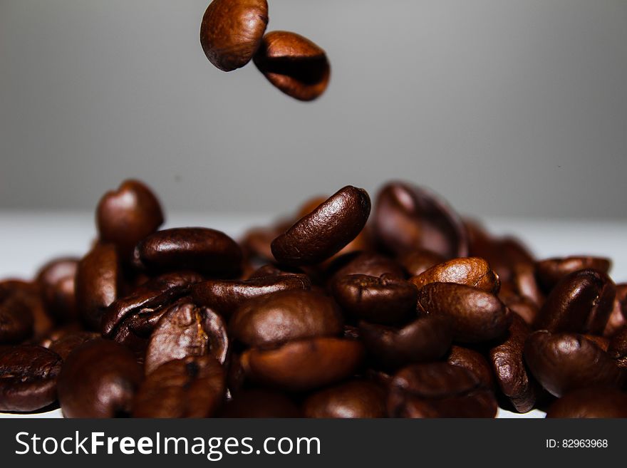 A close up of roasted coffee beans falling.