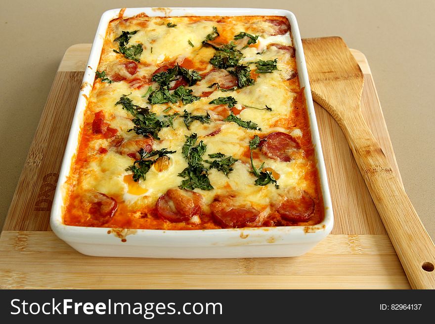 A baked tomato and sausage casserole with cheese on top. A baked tomato and sausage casserole with cheese on top.