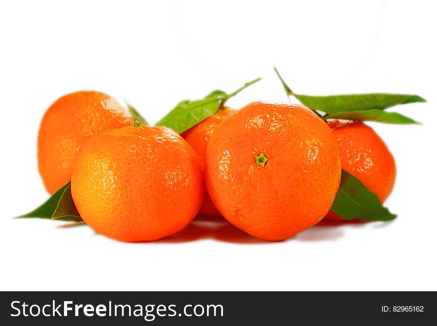 Close up of whole oranges and green leaves isolated on white. Close up of whole oranges and green leaves isolated on white.