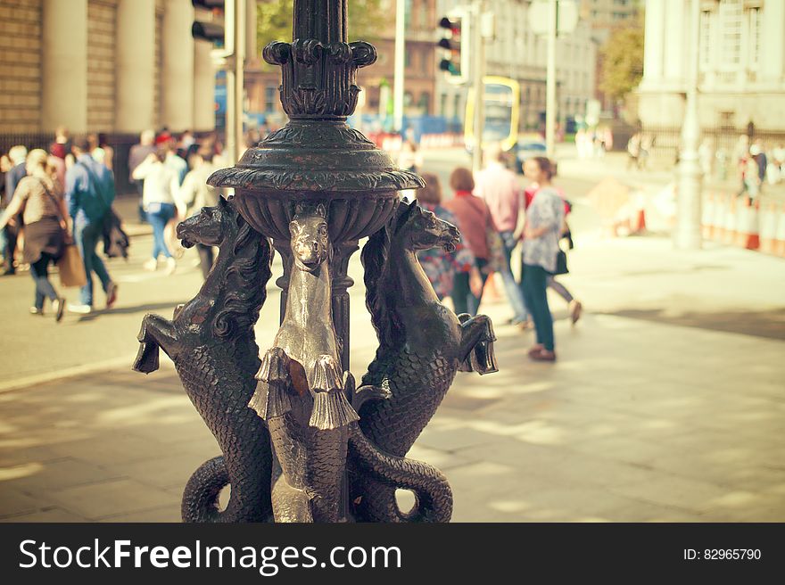 Gold seahorse statue in city square on sunny day.