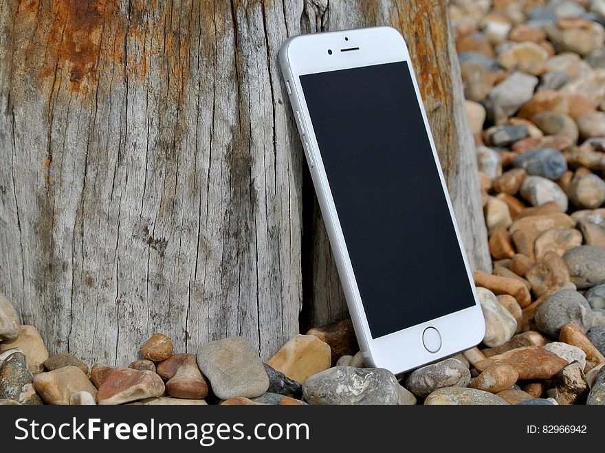 Silver Iphone 6 on Gray and Brown Stone