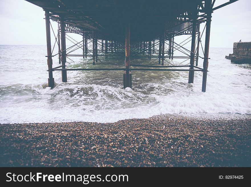 Brown Sand Beside Seashore and Wave of Water during Day Time