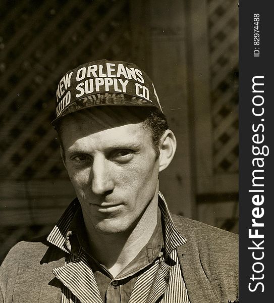 Black and White Photo of Man Wearing New Orleans Supply Hat