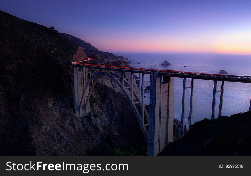 Time Lapse Photography of Cars Running on Bridge Near Ocean