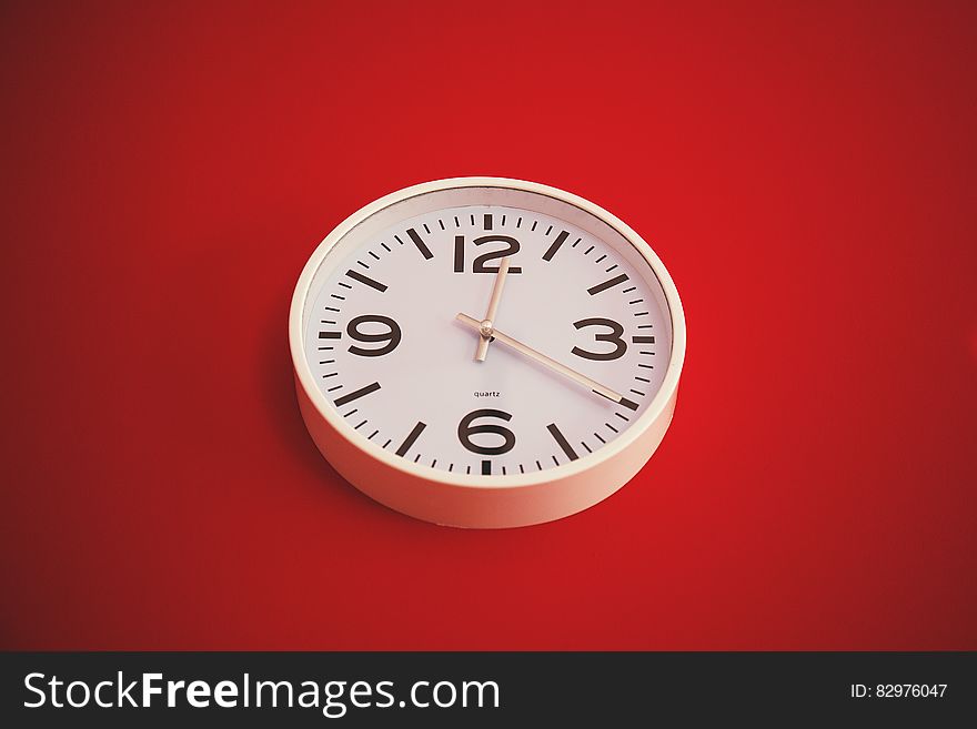 Close up of clock on red interior wall. Close up of clock on red interior wall.