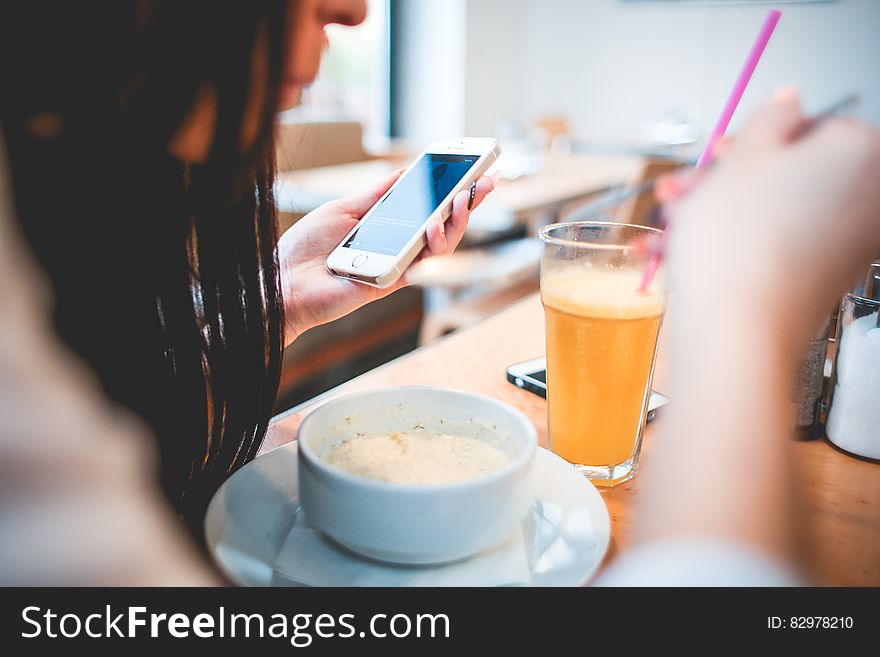 Human Holding Iphone Infront on White Round Bowl