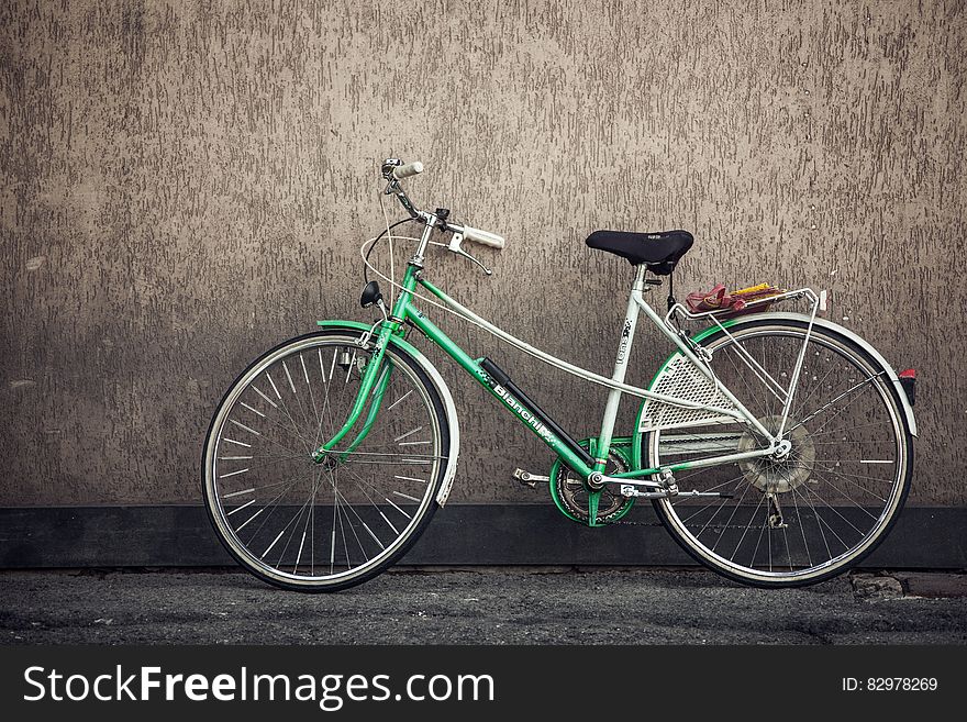 Green bicycle leaning against exterior wall. Green bicycle leaning against exterior wall.