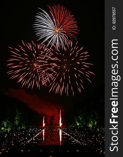 Red and White Fireworks Scattered during Nighttime