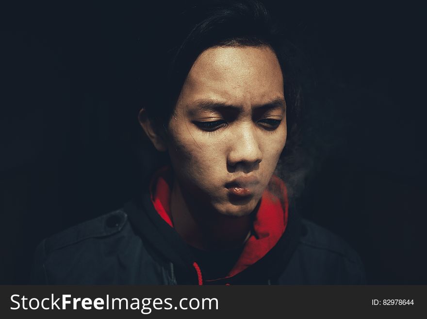 Studio portrait of Asian man in red and black jacket with serious expression. Studio portrait of Asian man in red and black jacket with serious expression.