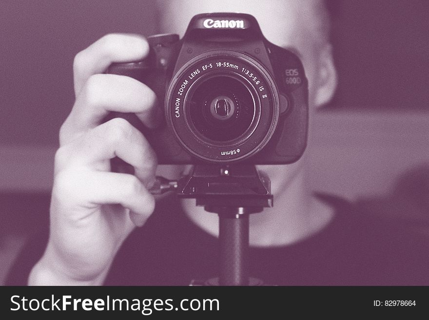 Portrait of photographer behind Canon DSLR camera in black and white. Portrait of photographer behind Canon DSLR camera in black and white.