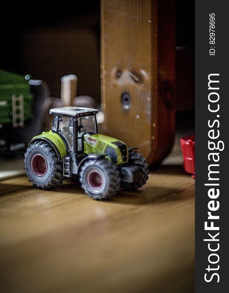 Close up of plastic toy tractor in room.