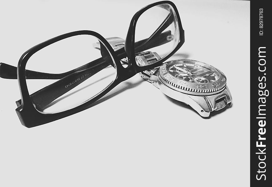 Close up of eyeglasses and wristwatch in black and white. Close up of eyeglasses and wristwatch in black and white.