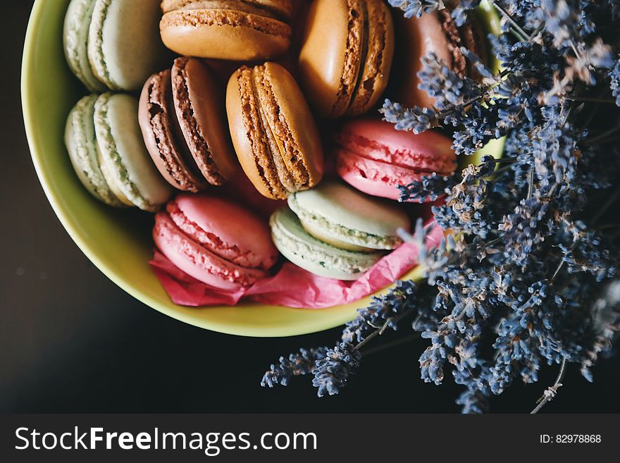 A cup of French macarons with lavender flowers.