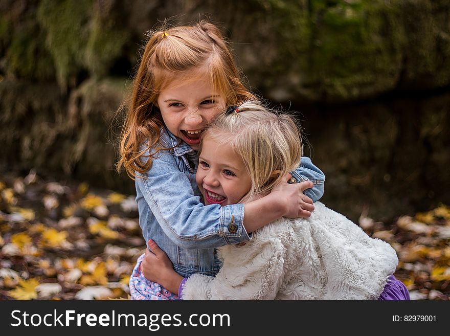 2 Girls Hugging Each Other Outdoor during Daytime