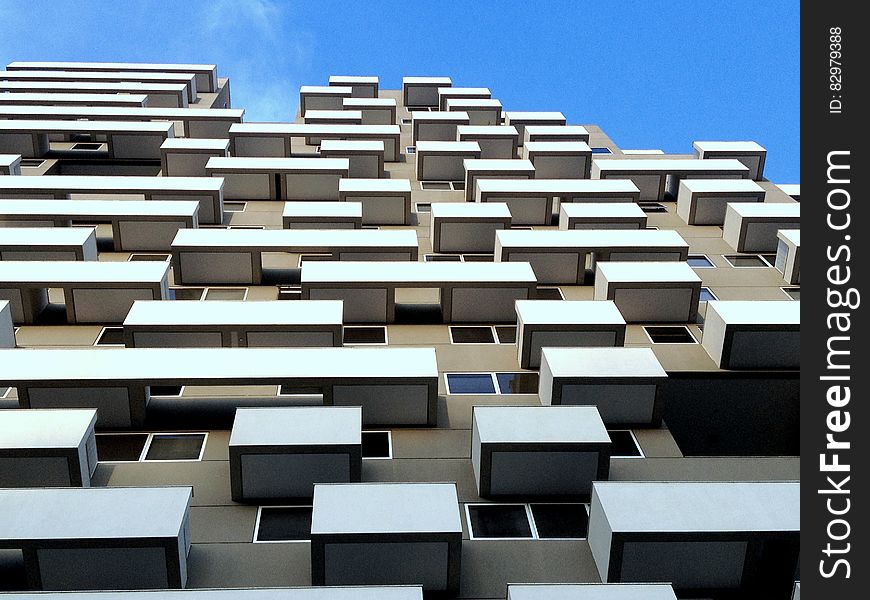 High rise apartment block with almost identical windows and balconies, clear blue sky background. High rise apartment block with almost identical windows and balconies, clear blue sky background.