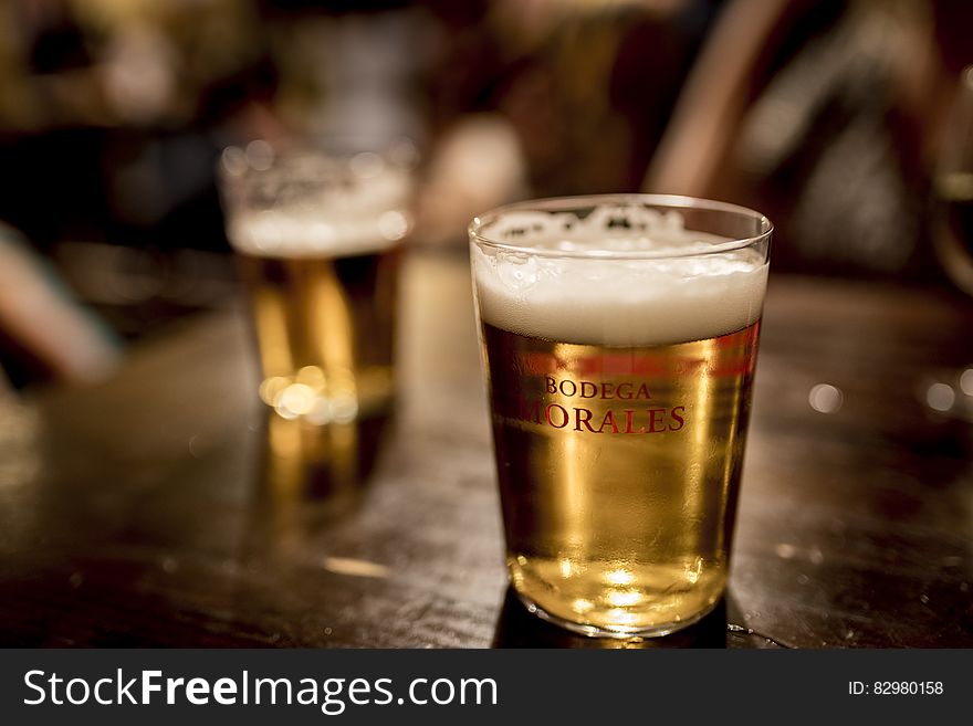 Close up of glasses of beer on indoor wooden table. Close up of glasses of beer on indoor wooden table.