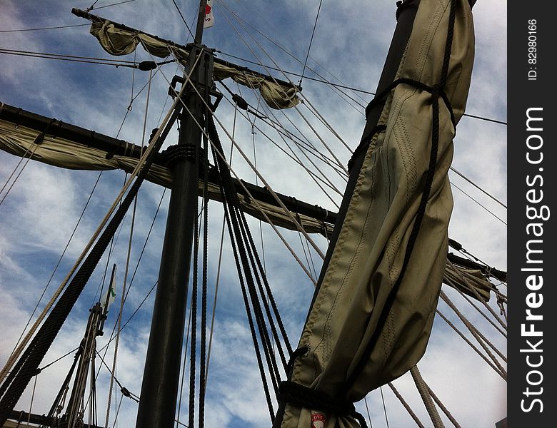 Sails folded on masts on sailboat against blue skies on sunny day. Sails folded on masts on sailboat against blue skies on sunny day.