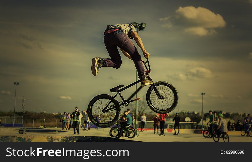 Man performing tricks on bicycle at skate park on sunny day. Man performing tricks on bicycle at skate park on sunny day.