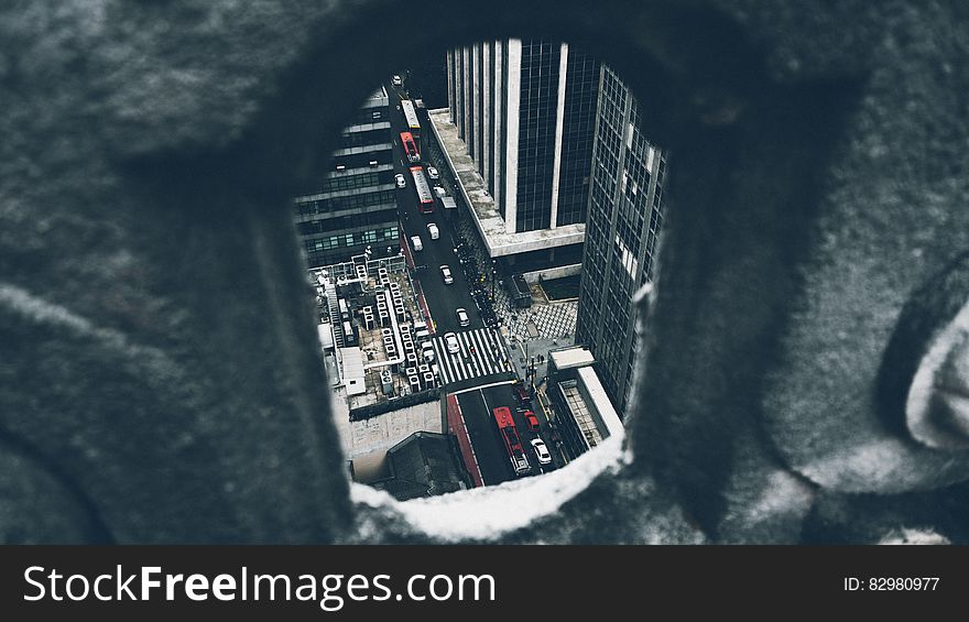 Aerial view of busy traffic on city streets viewed through gap in wall.