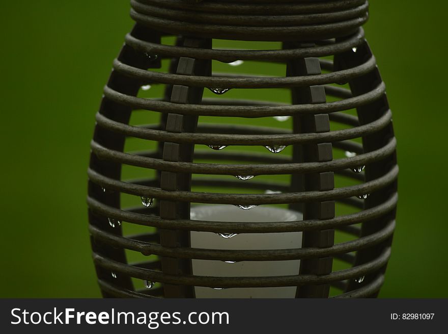 Close up of water drops on metal container against green background.