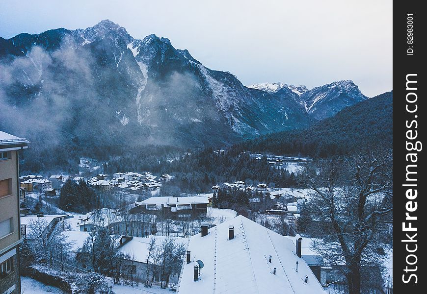 Snow Covered House Near Snow Covered Mountain Under Clear Sky