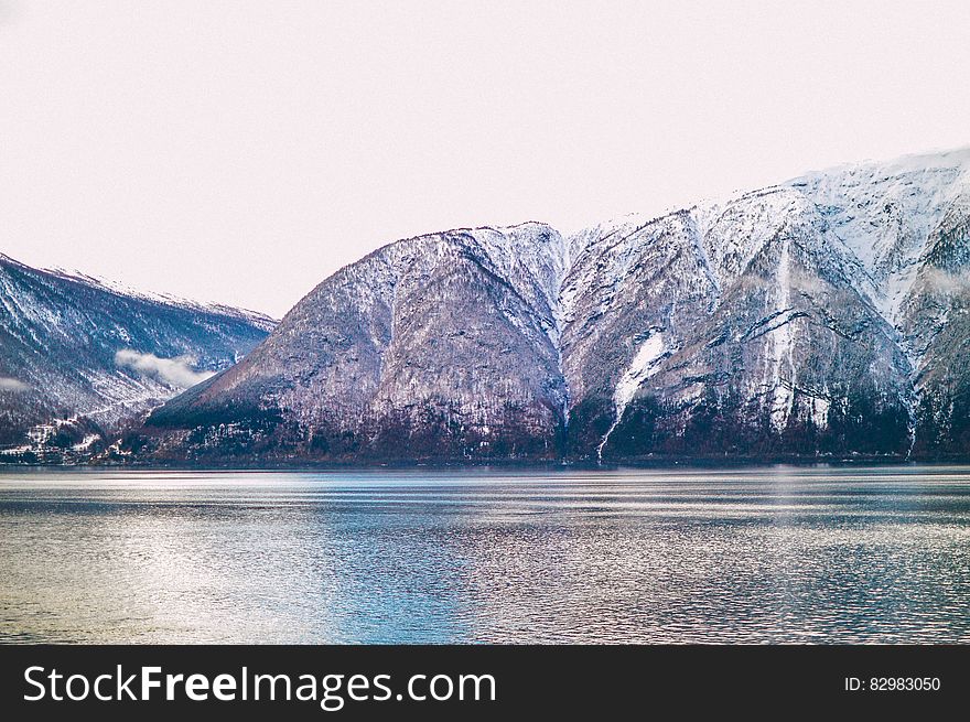 A lake with snowy mountain range behind it. A lake with snowy mountain range behind it.