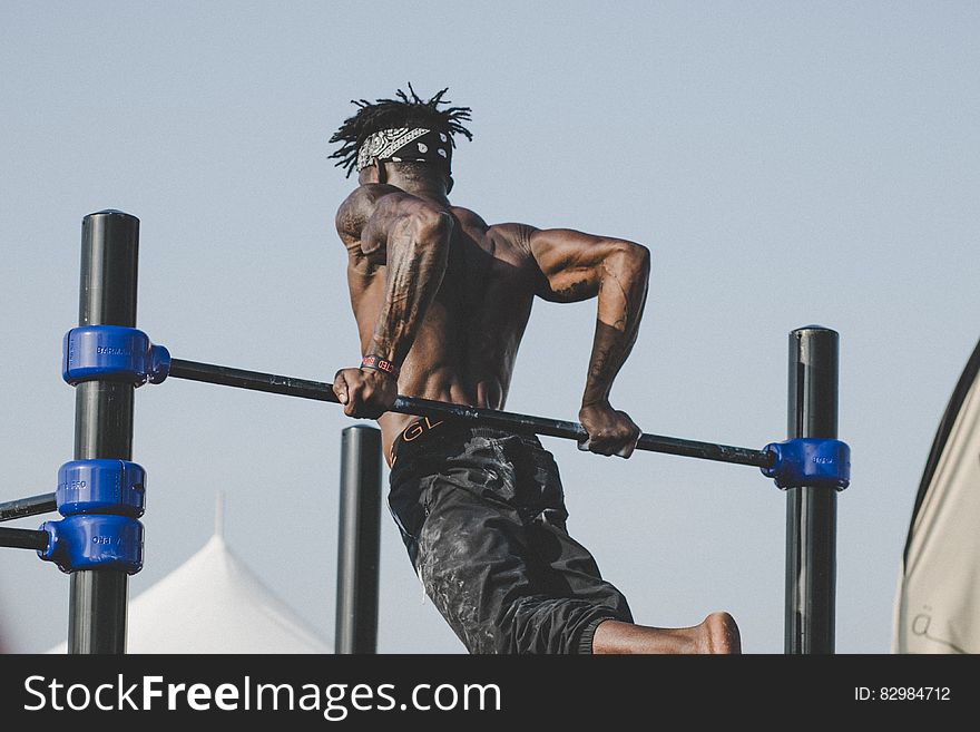 A man doing his workout on a high bar. A man doing his workout on a high bar.